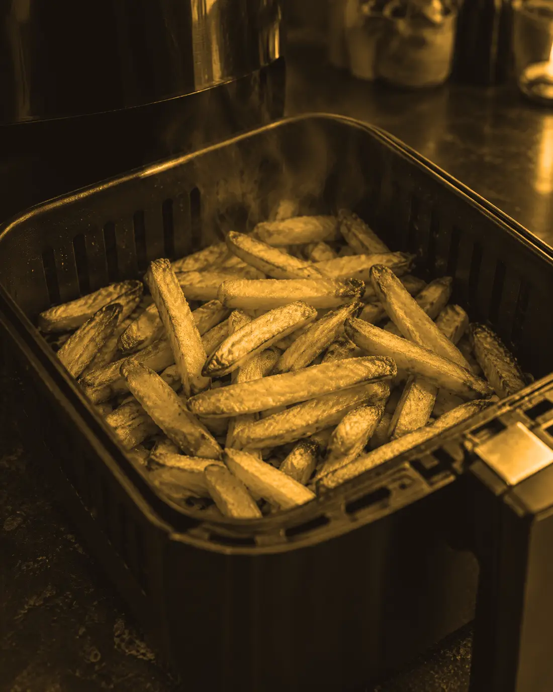 Een mand met goudbruine friet, net uit de airfryer (AI-beeld)